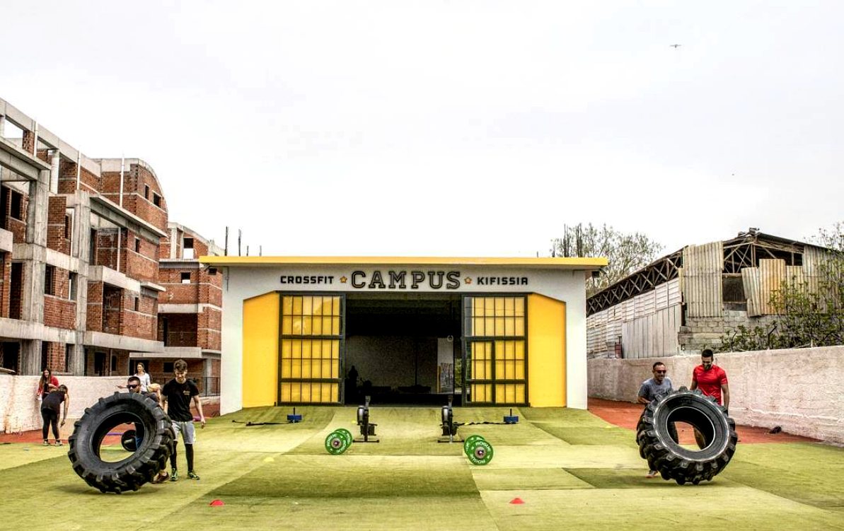 The Campus Kifissia box — the yellow CrossFit Campus Kifissia building with tyre flips on the turf outside